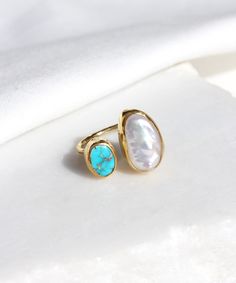 14K Gold Plated Raw Turquoise and Baroque Pearl Adjustable Ring A beautiful raw turquoise and freshwater pearl ring with a modern design. Very versatile, comfortable and chic, this ring will add a precious touch to your outfits. We are sure that it will bring you compliments here and there. Highly regarded for millennia, turquoise has been treasured as a divine gift that fell from heaven, reflecting the color of the sky in some traditions, and water in others. The captivating sea-green stone of Diamond Turquoise Ring, Pearl And Turquoise Ring, Gold And Turquoise Jewelry, Blue Gemstone Ring, Silver Pearl Ring, Raw Turquoise, Gold Bangles For Women, Turquoise Gold Ring, Precious Stones Rings