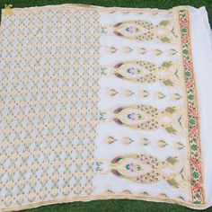 two pieces of white and gold cloth on green grass