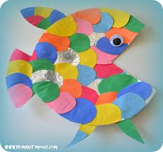 a fish made out of colored paper on a blue background