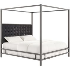 a bed with white sheets and a black headboard on it's end frame