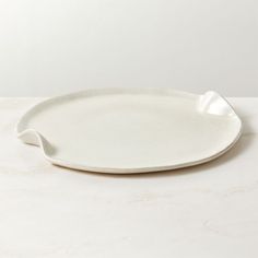 a white oval platter on a marble table