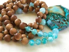 "Tranquility Mala Beads - Ocean Jasper & Sandalwood Beads - Hand Knotted - 108 Bead Mala - Length approx. 40\" The rhythmic cadence of the sea has always called humanity to its shores. This Ocean Jasper and Sandalwood Mala bead necklace from True Nature Jewelry brings that same spirit of peace and letting go. Hand knotted for flexibility and beauty, it features soothing and fragrant Sandalwood beads and Light Aqua Agate to help balance the emotions. A large Ocean Jasper pendant which brings Earthy Hand-strung Beaded Necklaces For Meditation, Nature-inspired Beaded Necklace With Wooden Beads, Nature-inspired Wooden Beaded Necklace, Hand-strung Nature-inspired Beaded Necklaces, Nature-inspired Hand-strung Beaded Necklaces, Sandalwood Mala, Mala Bead Necklace, Meditation Beads, 108 Mala Beads