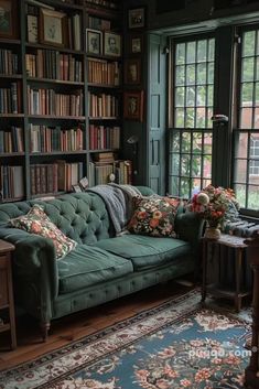 a green couch sitting in front of a window filled with lots of bookcases