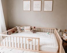 a baby crib with two pictures on the wall