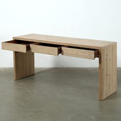 a wooden table with two drawers on it's sides, in front of a white wall