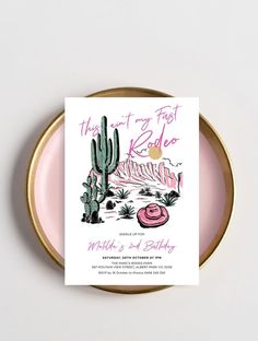 a pink and gold plate with a card on it that says, the desert is alive