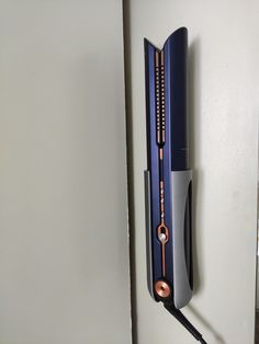 a wall clock that is on the side of a door with a cord attached to it