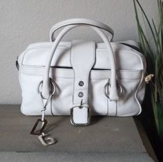 "DULCE & GABBANA Off White Pebbled Leather Satchel Bag Purse  * Dolce & Gabbana * 100% Authentic - Certified Authentic by Authenticate First. You Will Receive a Copy of the Certificate of Authenticity. * Style: Large Satchel  * Made of an Off White Pebbled Leather. * Heavy Duty Silver Toned Brass Hardware.  * Signature DG Signature Hang Fob. * Double Hasndles w 7 \" Drop * Top Zipper Closure w a Leather and Metal Zipper Pull That Slide Locks on the Side of the Purse. * Faux Buckle Top Strap that White Satchel With Double Leather Handles, White Satchel Bag With Detachable Handle, White Leather Satchel With Detachable Handle, White Textured Leather Satchel, Pebbled Leather Satchel With Silver-tone Hardware, Buckle Top, White Pebbles, Bag Measurements, Leather Satchel Bag