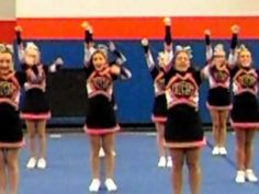 a group of cheerleaders standing on top of a blue floor