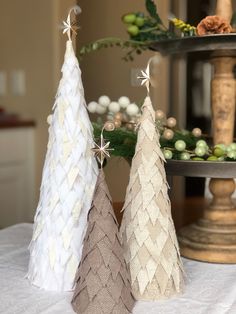 three small christmas trees sitting on top of a table