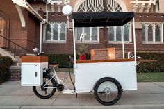 an ice cream cart is parked on the sidewalk