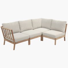 a wooden sectional couch with pillows on it's back and side ends, in front of a white background