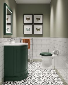 the bathroom is decorated in green and white colors, with pictures on the wall above the toilet