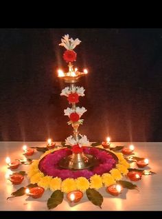 a candle holder with flowers and candles on it