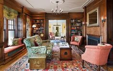 a living room filled with lots of furniture and bookshelves next to a fire place