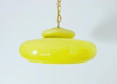 a yellow light hanging from a metal chain