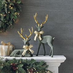 two deer figurines sitting on top of a mantle