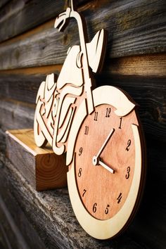 a wooden clock that is on the side of a building with a motorbike carved into it