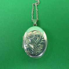 Description : A pretty hallmarked sterling silver oval locket with stylised engraved decoration together with its silver chain. Marks : Hallmarked silver for Birmingham 1992.  Maker's marks ZJ. Weight : It weighs 6.2 grams. Size :  Locket : 2.7cm long, 2cm wide. Chain : 46.5cm long Condition : In very good condition. FREE UK POSTAGE. Silver Oval Pendant Locket Necklace, Silver Oval Pendant Locket Necklace With Polished Finish, Silver Locket Necklace With Polished Oval Pendant, Vintage Silver Oval Pendant Locket Necklace, Vintage Engraved Oval Pendant Locket Necklace, Classic Silver Oval Link Locket Necklace, Classic Silver Locket Necklace With Oval Link, Vintage Engraved Oval Locket Necklace, Antique Silver Oval Necklace