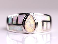 // Solid Sterling Silver White Fire Opal Inlay Ring // This high-quality ring is made with white fire opal, which is a man-made gemstone. The gemstones are carefully inlaid together to create this beautiful geometric design!  The ring measures 9mm at the widest point. Each ring contains fire opals that create an iridescent effect that can't be quite captured in a photo! The opal colors shimmer, depending on the lighting and angle. Thanks for looking! Modern White Opal Gemstone Ring, Modern White Opal Ring, Opal Inlay Ring Gift, White Teardrop Opal Ring For Gift, Opal Ring With Inlay Perfect For Gifts, Gift Opal Inlay Ring, Fire Opals, Inlay Jewelry, Opal Color