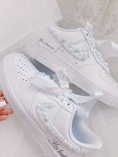 a pair of white sneakers with pearls on them