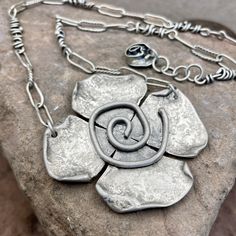 "This bold statement necklace features a large flower with a spiral center. This piece hangs from a mixed chain that is comprised of smooth and textured oval links and wrapped vine pieces. Certainly a special piece! The matte finish is really something else! Adjustable from approximately 17\"-18\" in length. brushed finish Sterling Silver. This necklace is handmade and specially oxidized and then polished to add dimension and contrast to really bring out the organic and natural beauty of the met Unique Flower Pendant Necklaces With Charm, Vine Necklace, Floral Statement Necklace, Bold Statement Necklaces, Spiral Necklace, Large Necklace, Basic Jewelry, Necklace Flower, Matching Bracelets