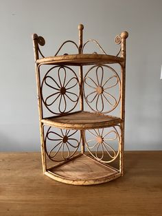 a three tiered wooden shelf with wheels on the top and bottom, sitting on a wood table