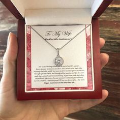 a person is holding up a necklace in a box with the words, to my amazing mother in law on it