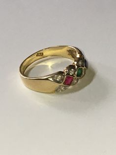 Beautifully vintage. Solid, stamped 14K Yellow Gold band ring. Features round cut red Ruby, blue Sapphire, green Emerald gemstones with round cut stones, possibly faux diamonds or topaz. Ring and stones show use, wear, and imperfections commensurate with age. Do not have any additional information on the stones. Ring size approximately 6.5. Vintage Multi-stone Diamond Rings, Vintage Multi-stone Diamond Ring In Yellow Gold, Vintage Multi-stone Ruby Ring In 14k Gold, Vintage Multi-stone Sapphire Ring, Vintage Multi-stone Emerald Ring In 14k Gold, Vintage Yellow Gold Cluster Ring With Accent Stones, Multicolor Jeweled Rings For Anniversary, Vintage Jeweled Rings, Vintage Multi-stone Round Cut Jewelry