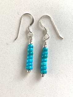 These are a pair of simple turquoise and sterling silver earrings. The turquoise is from the Kingman mine in Arizona. The rondelle beads are petite at 3-4 mm. There are teeny tiny sterling spacer beads at either end of the turquoise.  The earrings measure about 1 1/2 inches tall and will be secure on your ears with shepherd hook ear wires.  These earrings are quite petite!   These are the exact earrings you will be receiving, already made and ready to ship immediately. Designed and made by me. P Turquoise Sterling Silver Jewelry With Tiny Beads, Sterling Silver Blue Jewelry With Tiny Beads, Blue Sterling Silver Jewelry With Tiny Beads, Sterling Silver Earrings With Tiny Round Beads, Turquoise Dangle Jewelry With Tiny Beads, Sterling Silver Dangle Jewelry With Tiny Beads, Handmade Turquoise Earrings For Everyday, Turquoise Round Bead Earrings For Everyday, Turquoise Wire Wrapped Beaded Earrings As Gift