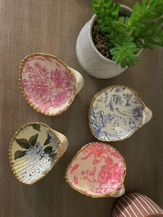 four small plates with designs on them next to a potted plant