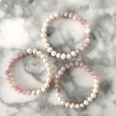 These gemstone + pearl beaded bracelets have us dreaming of a vacation! Stunning gemstones and fresh water pearls are the best of both worlds in these on trend beauties! Layer two or three together or pair with our pearl or gold ball bracelets. Details:- Rose Quartz Beading - Fresh Water Pearls - Stretches to fit most wrists approximately 7" in length Free U.S. Shipping on orders over $50!Your jewels will arrive in one of our velvet gift pouches. Perfect for gifting, storing your delicate jewels Luxury Pink Pearl Bracelet With Round Beads, Ball Bracelet, Fresh Water Pearls, Water Pearls, Pearl Gemstone, Pearl Bracelet, Pearl Beads, Live Lokai Bracelet, Types Of Metal