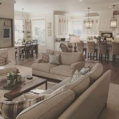 a living room filled with furniture next to a kitchen and dining room table in a home