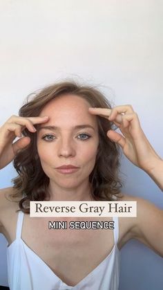 a woman is holding her hands up to her ears and looking at the camera with an ad for reverse gray hair