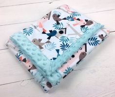 two baby blankets on top of each other, one with blue and pink birds in the background