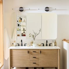 a bathroom vanity with two sinks and mirrors