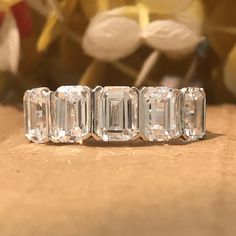 an emerald cut diamond ring sitting on top of a table