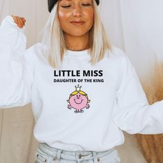 These Sweatshirts are perfect for everyone! Not only cute but SO COMFY! You cannot go wrong with this Little Miss Daughter of the King sweatshirt for yourself or as a gift. Our shirts are made with the best quality materials and are so soft. How to order: 1. Select Your Sweatshirt Size and Color from drop down menus.  2. Add to cart & place order. Shipping and Production: Order Production is 5-10 days. Holidays may be slower delivery times. Your orders will be shipped within the production days and will arrive in timely manner. Satisfaction Guaranteed!  Care Instructions: Wash the sweatshirt inside out with cold water. Tumble or low heat dry recommended. Returns and Exchanges: All sales are final but if the item is damaged when you receive it, we will replace it at no cost to you. Please t Funny Crew Neck Sweatshirt With Print, Funny Long Sleeve Tops With Text, Funny White Long Sleeve Tops, White Long Sleeve Sweatshirt With Funny Text, Funny White Sweatshirt With Text Print, Funny Long Sleeve Slogan Tops, Funny Long Sleeve T-shirt With Text, White Long Sleeve T-shirt With Funny Text, White Long Sleeve Tops With Funny Text