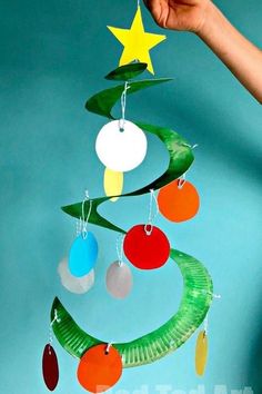 an image of a christmas tree made out of paper and plastic circles with ornaments hanging from it