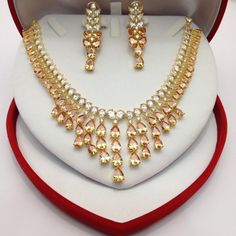 "CZ American Dimonds Heavy Gold Plated Cubic Zirconia Bridal Indian Jewelry Wedding Necklace Set Handmade indian Jewellery It is a perfect match with formal attire on special occasions or with casual wearing.  Comes With Jewellery Gift Box 1-Necklace, 1-Pair Of Earrings,  Earrings Length: 2.2\"inches Traditional Indian Wedding Jewellery Slight Colour variations possible due to difference in screen and photograph  Care instructions Keep Jewellery away from direct heat, water, perfumes, deodorants and other strong chemicals as they may react with the metal or plating. The plating composition of Jewellery is as such that  perspiration (sweat) will not damage it. Wipe Jewellery gently with chamois cloth or leather swatch after every use. Wiping the jewellery with a soft cloth after removing th Gold Crystal Jewelry Sets With Jeweled Details, Gold Cubic Zirconia Jewelry For Festivals, Gold Bridal Sets With Hand Set Crystals, Gold Necklace With Stone Work In American Diamond, Gold American Diamond Jewelry Sets For Diwali, Diwali Gold Jewelry Sets With American Diamonds, Gold Temple Jewelry Bridal Necklace With American Diamond, Gold Bridal Necklace With American Diamond In Temple Style, Gold Crystal Jewelry Sets With Stone Work