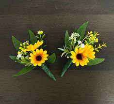 two yellow and white flowers sitting on top of a wooden table next to each other