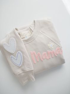 Custom Hand-Embroidered Mama Sweatshirt  This sweatshirt is extra soft and cozy! It's perfect for a day at home or running errands! The 'Mama' design is cut from felt and hand-stitched on the left chest. Check out the shop for a coordinating baby/toddler sweatshirt to match your little one! ---- DETAILS: - This listing is for one custom embroidered sweatshirt. Each item is made-to-order. Text is created in a cursive as shown. - Hearts are hand-stitched on the right sleeve unless otherwise reques Sweatshirt Embroidery Ideas, Custom Embroidered Sweatshirt, Mama Design, Womens Sweatshirts, Gifting Ideas, Embroidery Sweatshirt, Mama Sweatshirt, Embroidered Sweatshirt, Embroidered Sweater