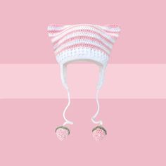 a pink and white knitted hat with two baby feet hanging from the side on a pink background