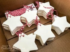 some white and red star shaped ornaments in a cardboard box with twine on top