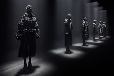 a group of mannequins are lined up in the dark