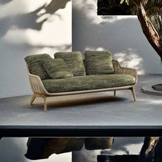 a couch sitting on top of a cement floor next to a tree and water puddle