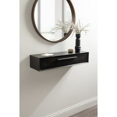 a black shelf with a mirror and vase on it