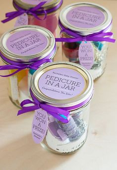 two jars with purple ribbons and labels on them