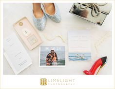 a table topped with shoes and personal items next to a pair of red high heels