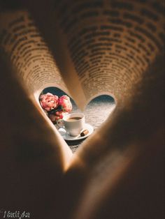 a cup of coffee and some flowers on a table